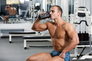 young caucasian bodybuilder in the gym, drinking a protein shake